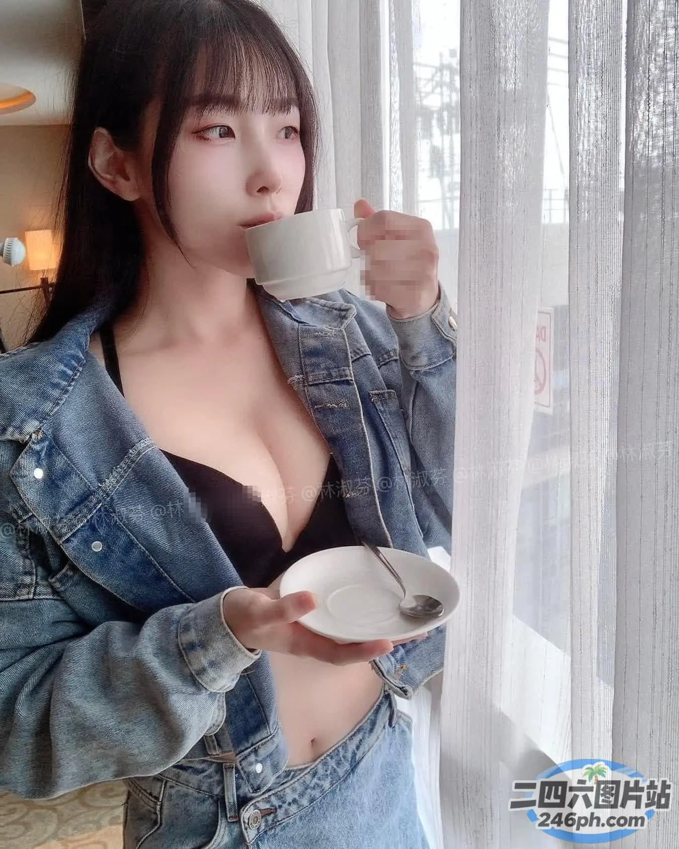 有个穿着牛仔夹克的女人，手里拿着一个罩杯
