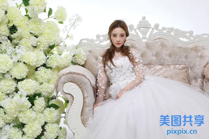 有一个女人穿着白色连衣裙坐在沙发上