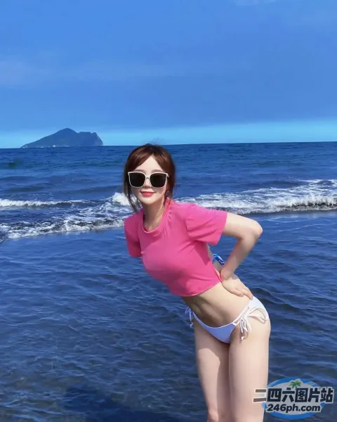 海滩上有个穿着粉色衬衫和白色短裤的女人