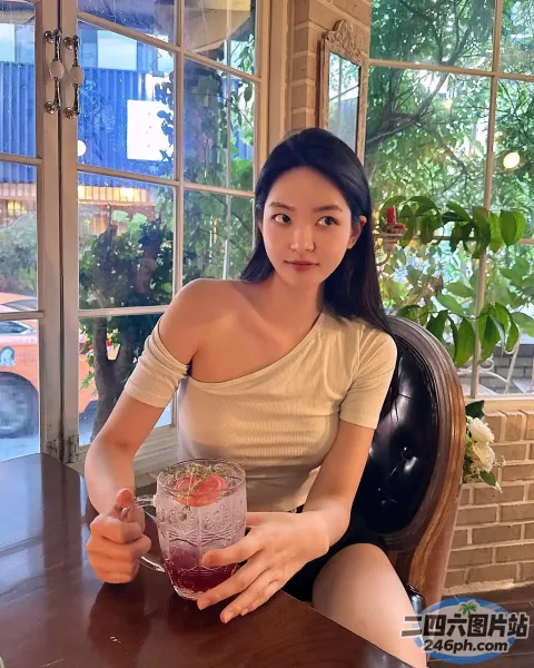 阿拉夫德女人坐在桌子旁，手里拿着一杯饮料