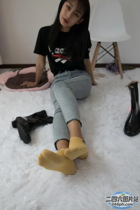 阿拉菲坐在白色地毯上，手里拿着一双鞋