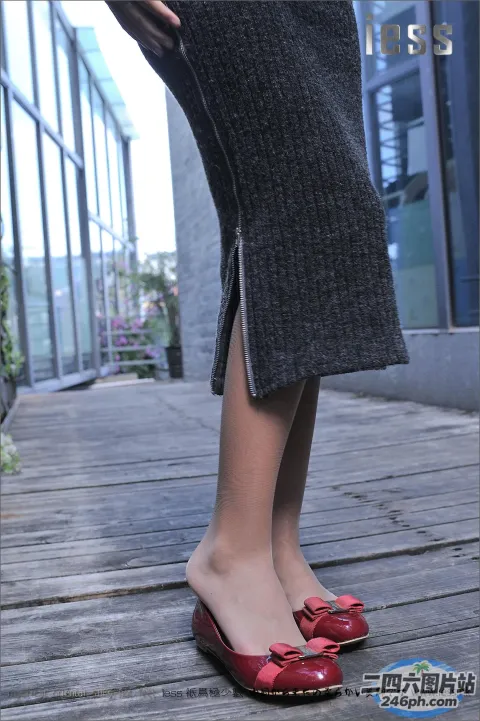 有一个女人站在木甲板上，穿着红色的鞋子