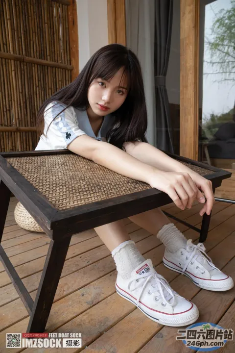 阿拉夫德女人坐在木凳上，双脚放在桌子上