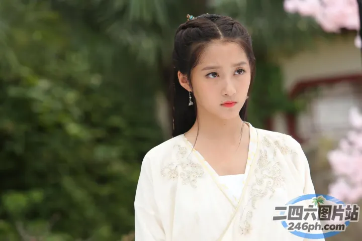 身穿白色连衣裙的阿拉夫德女子站在树前