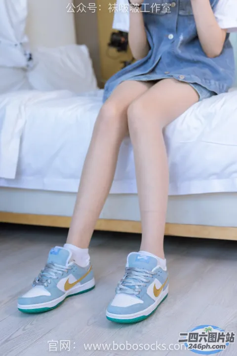 有个女人坐在床上，手里拿着手机