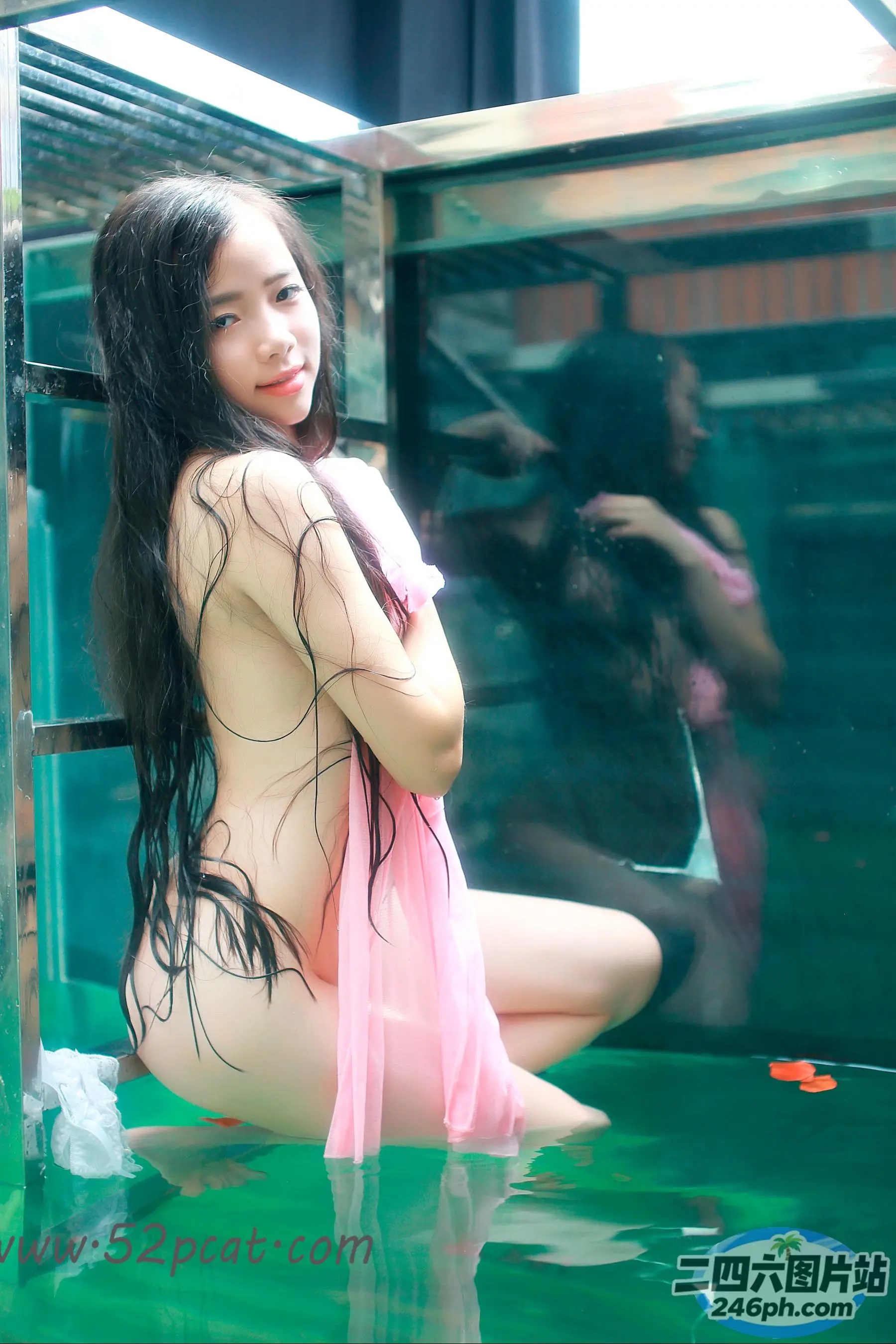 穿着粉红色连衣裙的 arafed 亚洲女性坐在背心里