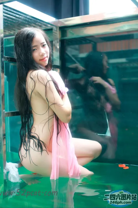 穿着粉红色连衣裙的 arafed 亚洲女性坐在背心里
