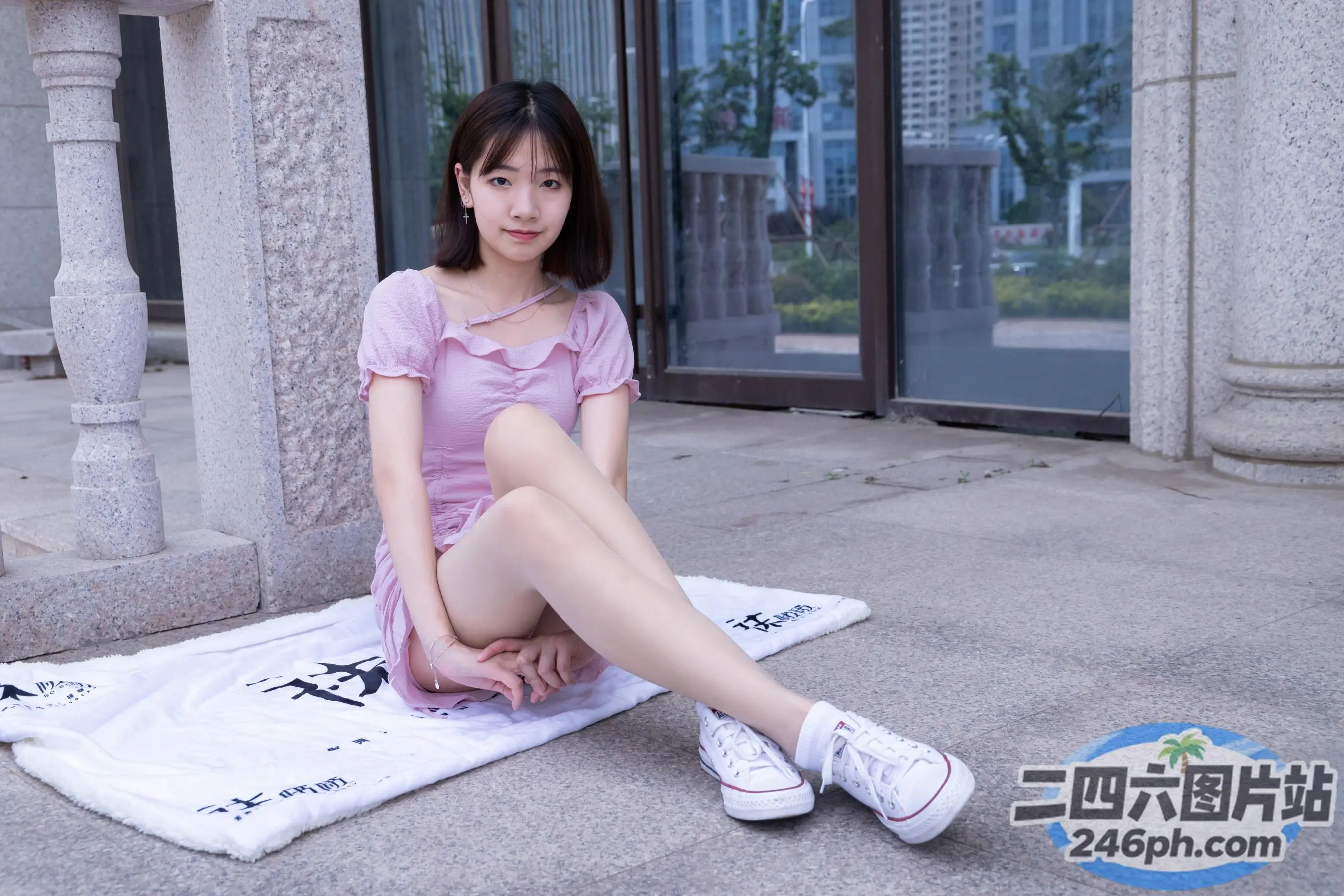 阿拉菲女子坐在地上的毛巾上，双腿交叉