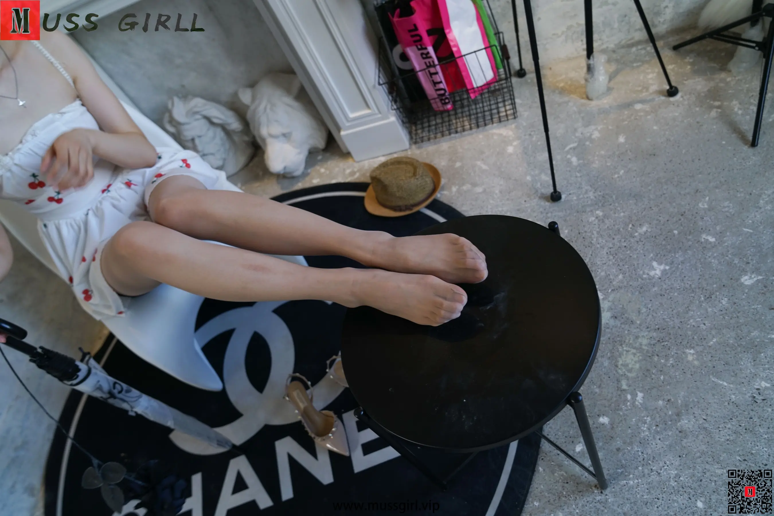 Araffe 坐在一把上面有 CHANEL 标志的椅子上
