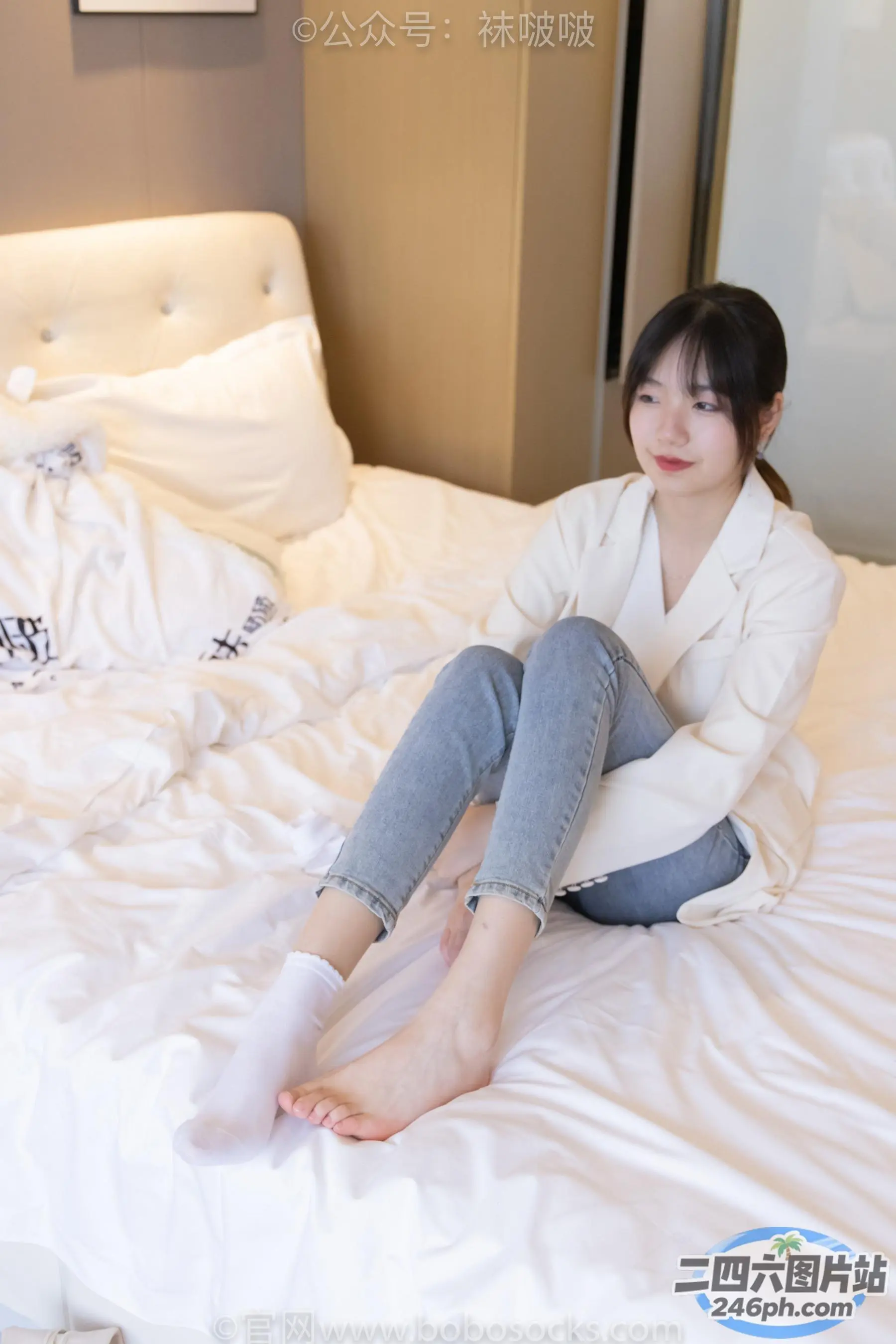 Araffe 坐在床上，穿着白色夹克和牛仔裤