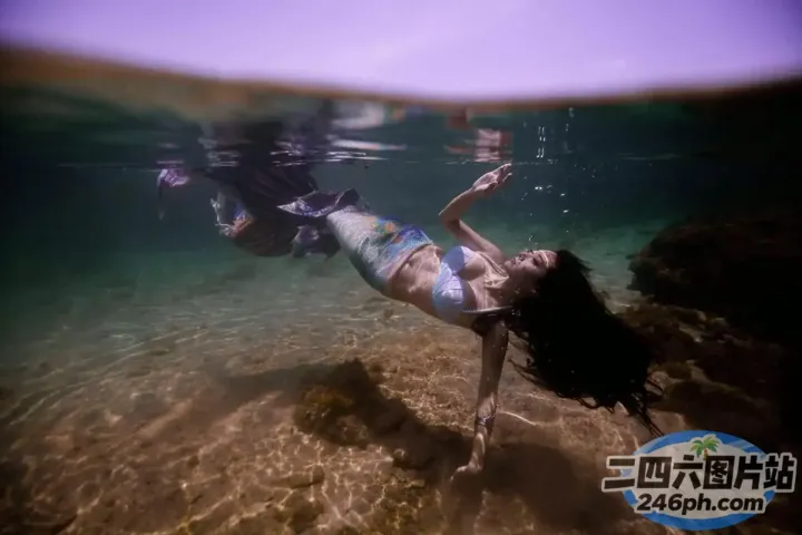 穿着比基尼的 arafed 女人在海里游泳