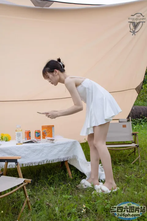 桌前站着一个女人，手里拿着蛋糕
