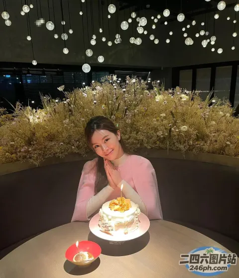 坐在桌子旁的女人，面前放着蛋糕和蜡烛