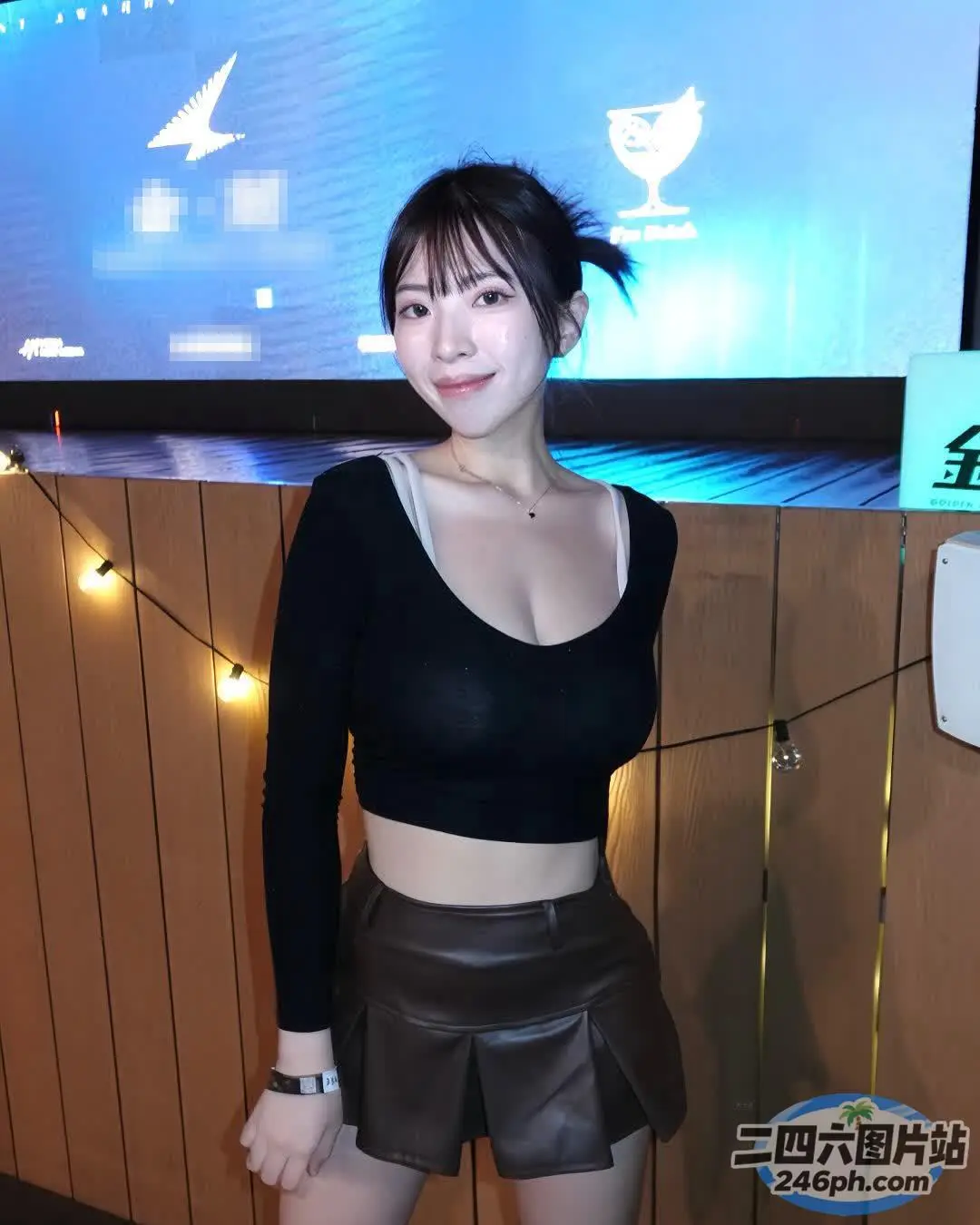 有一位身穿黑色上衣和黑色短裤的女子摆姿势拍照