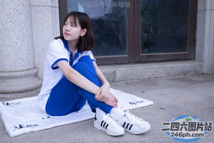 阿拉夫德女人坐在一栋楼前的毛巾上