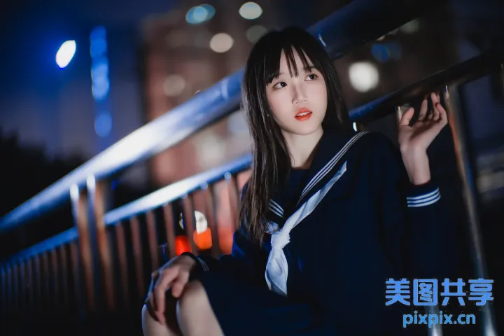 身穿水手服坐在栏杆上的亚洲女性