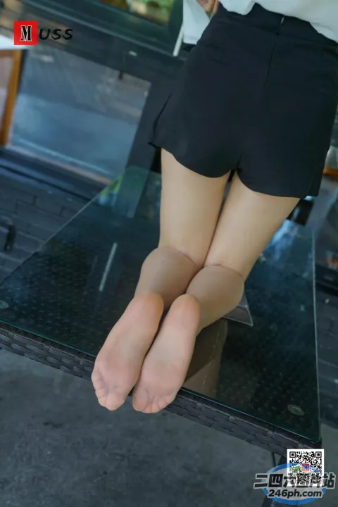 有一个女人坐在桌子上，双腿交叉