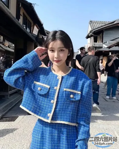 站在人行道上的身穿蓝色夹克和裙子的 araffe 女子