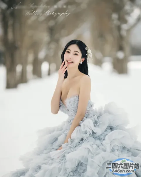 穿着灰色连衣裙坐在雪地里的 Arafed 女人