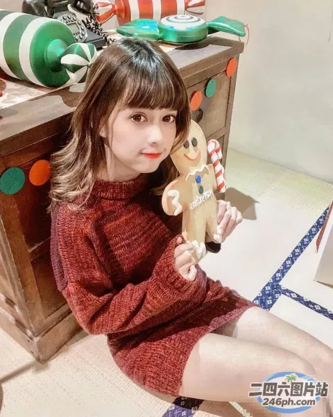 地板上坐着一个女孩，手里拿着一个木制姜饼