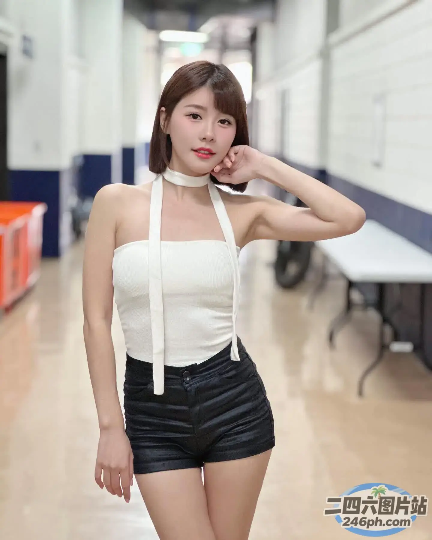 一名身穿白色上衣和黑色短裤的女子合影留念