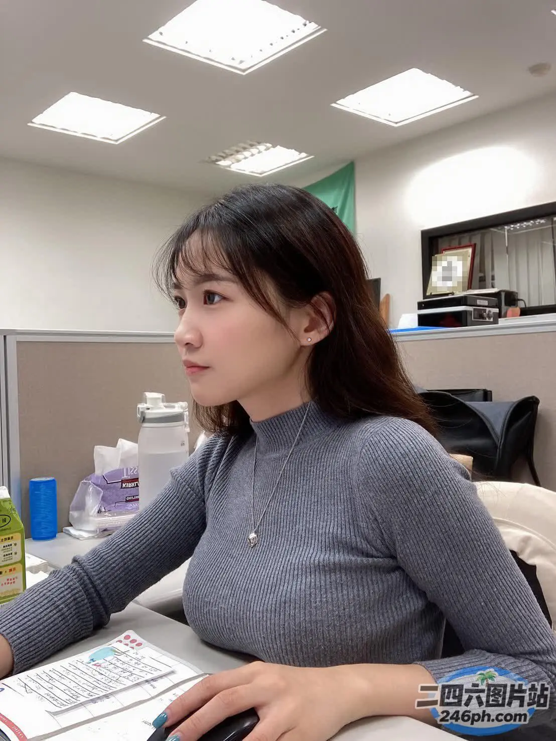 有个女人坐在桌子前，桌上放着一台电脑
