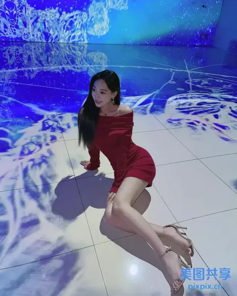 地板上坐着一个穿着红色连衣裙的女人