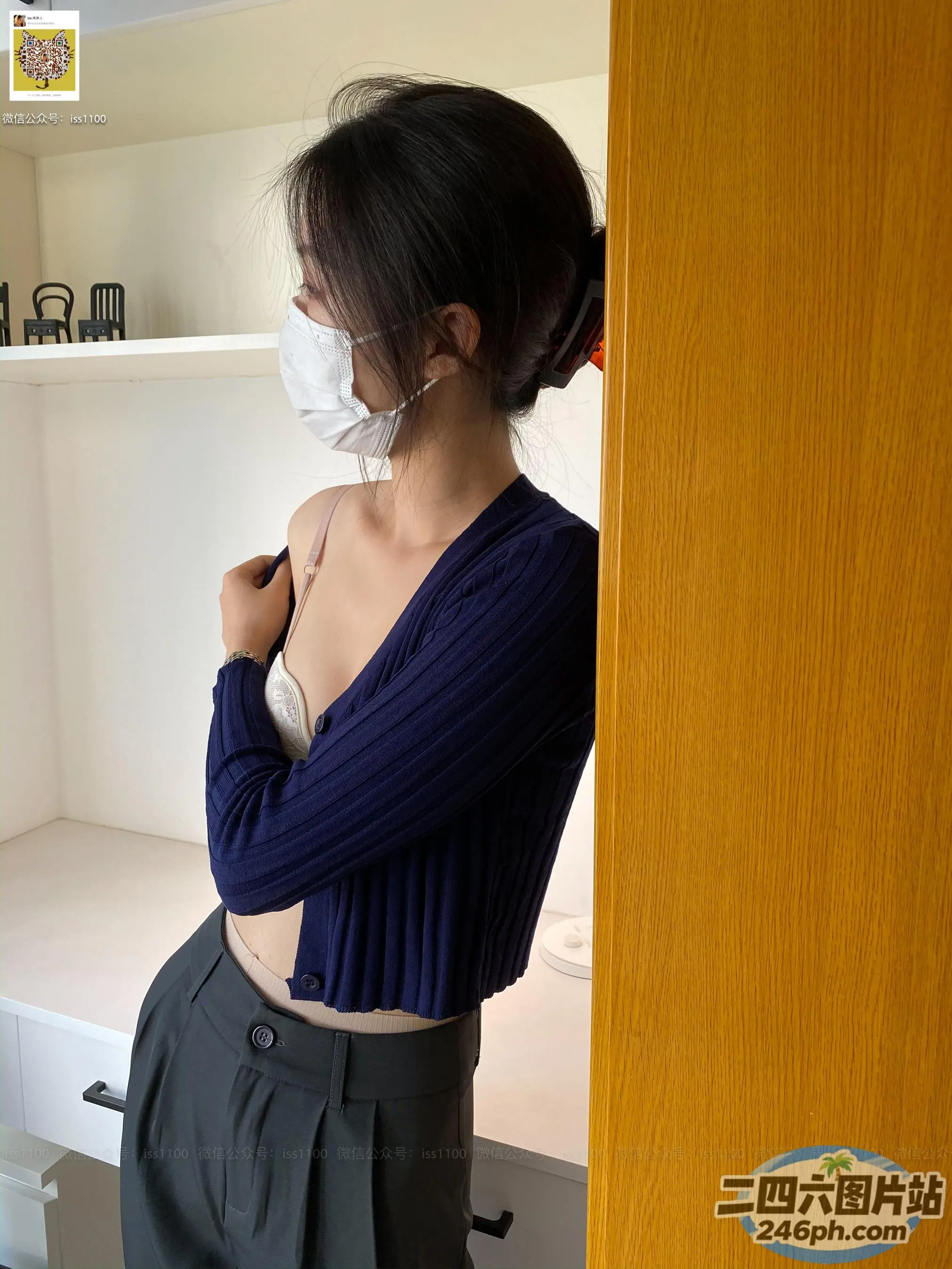 身穿蓝色衬衫和黑色裤子的阿拉夫德女人站在房间里