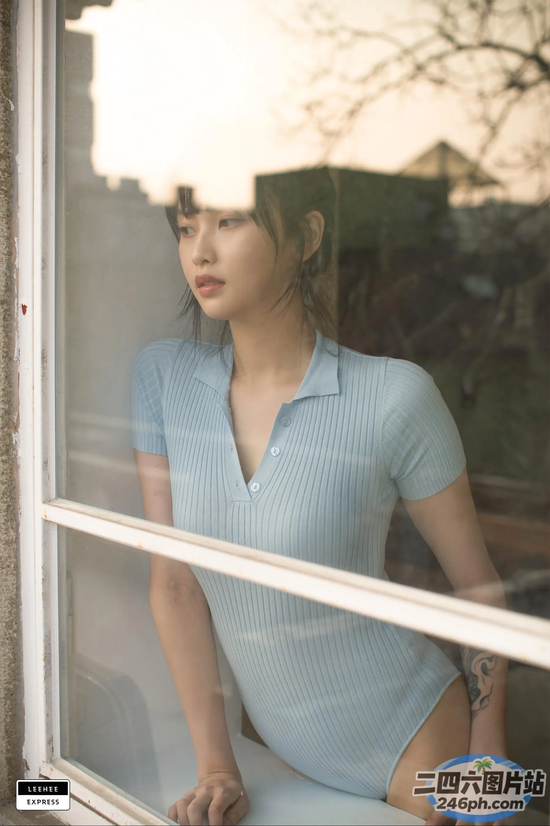 穿着蓝色衬衫的 arafed 女人望向窗外