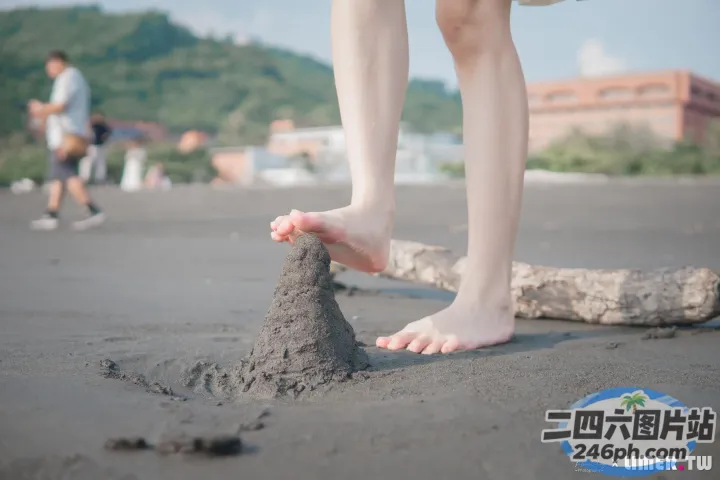 有一个人站在沙滩上，有一座沙堡