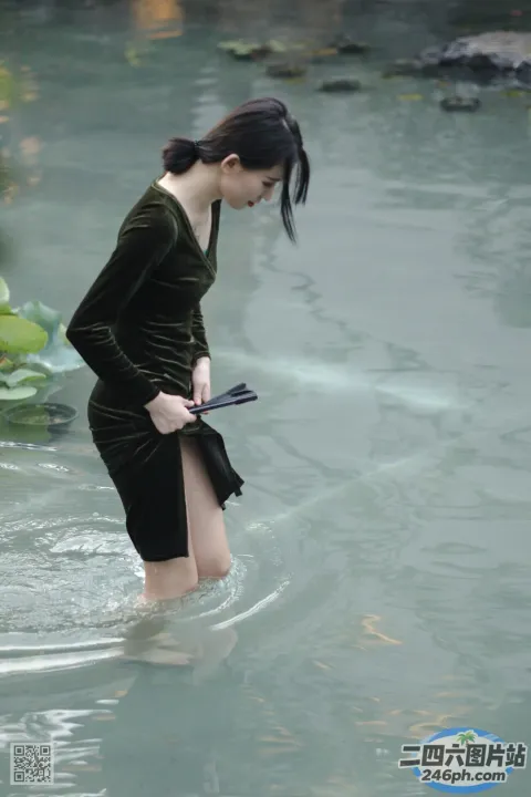 有个女人拿着平板电脑站在水里