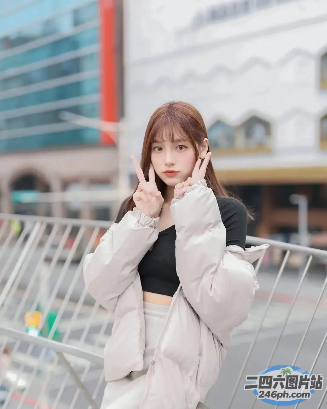 一名身穿白色夹克和黑色上衣的女子站在街上