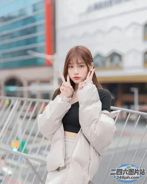一名身穿白色夹克和黑色上衣的女子站在街上
