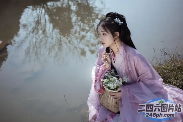 穿着粉红色连衣裙的 arafed 女人坐在池塘边，手里拿着一篮花