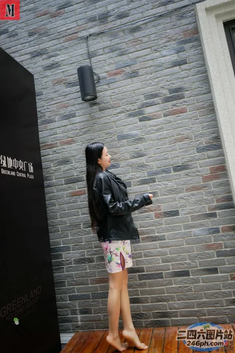 站在砖墙前拿着相机的阿拉菲德女人
