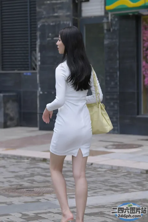 身穿白色连衣裙的 Araffe 女子提着钱包走在街上