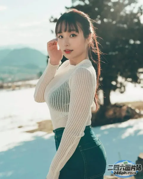 一个穿着白色毛衣和绿色裙子的女人站在雪地里