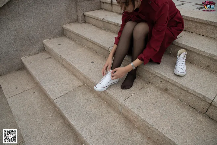 台阶上坐着一个女人，正在系鞋带