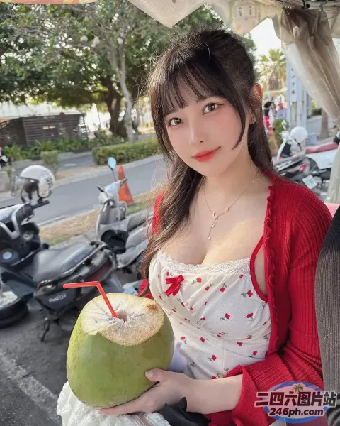 身穿红色开衫的 araffe 女孩，手里拿着椰子饮料