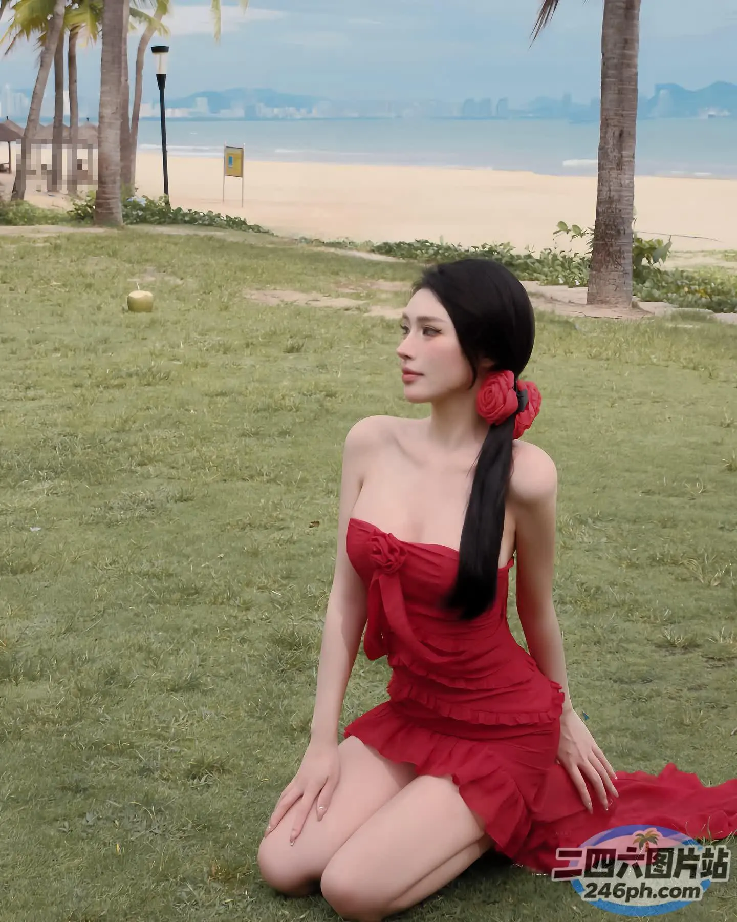 身穿红裙的阿拉伯女子坐在海滩附近的草地上