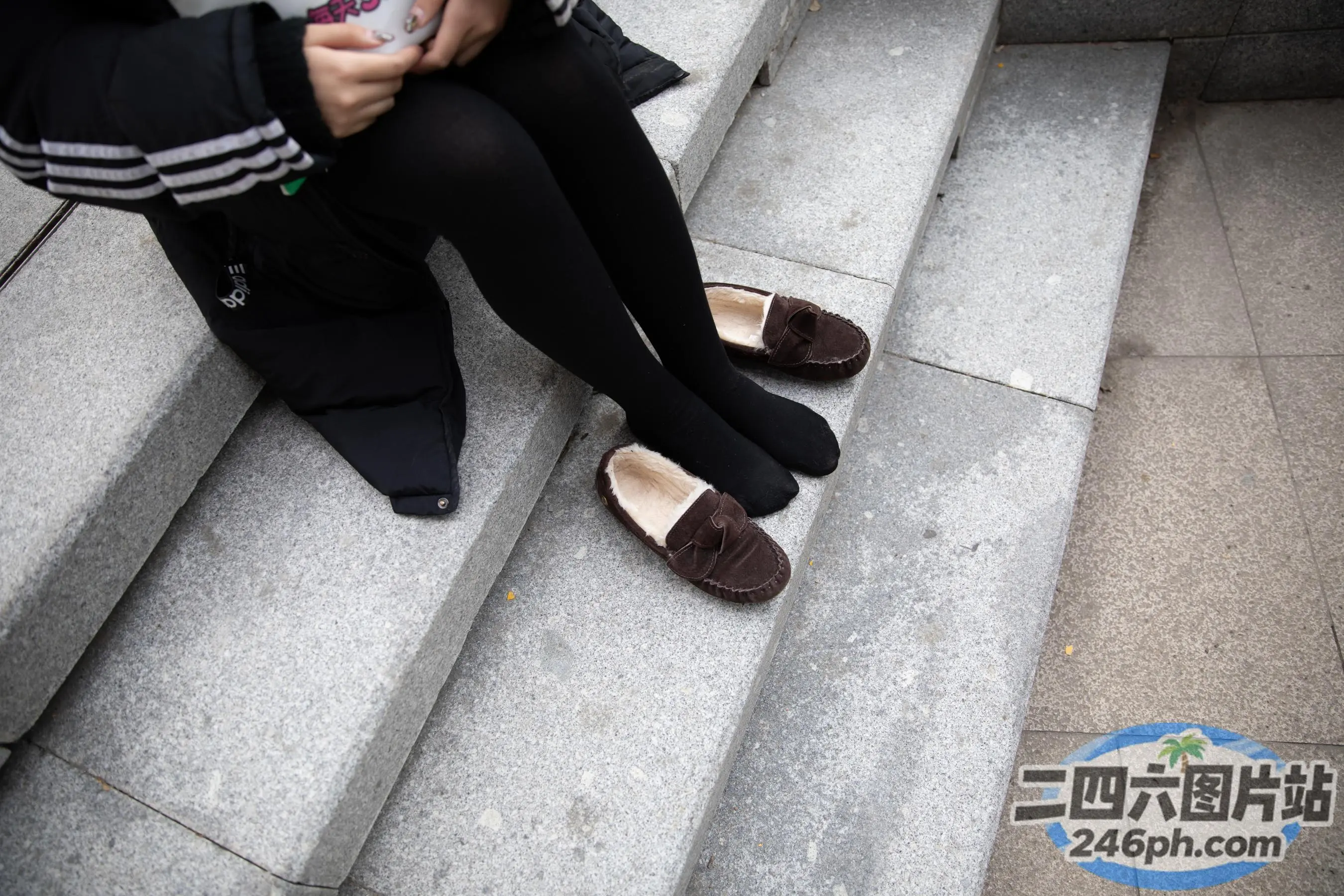 台阶上坐着一个女人拿着手机