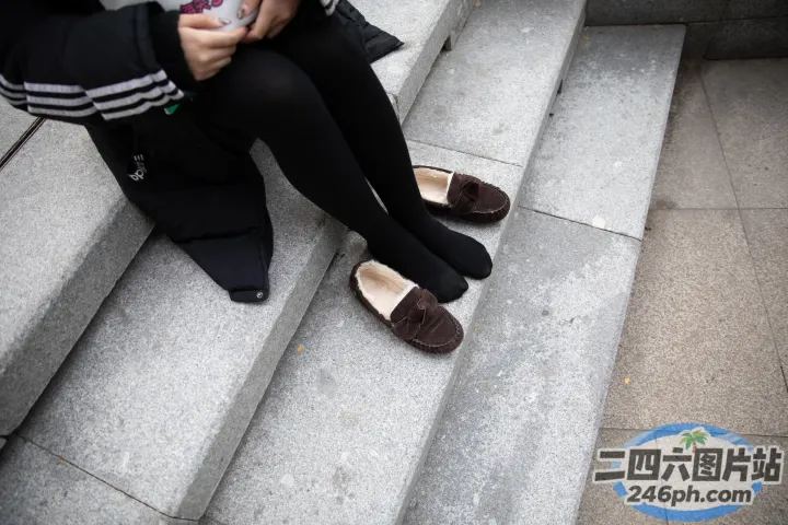 台阶上坐着一个女人拿着手机