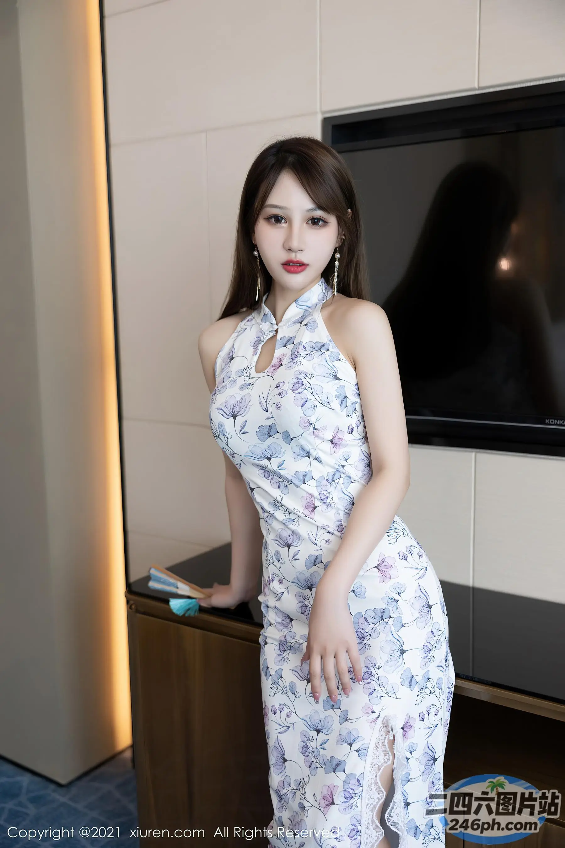 身穿白色连衣裙的阿拉伯裔女子在电视机前摆姿势
