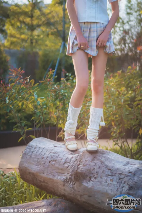 公园里站着一根木头上的一个年轻女孩