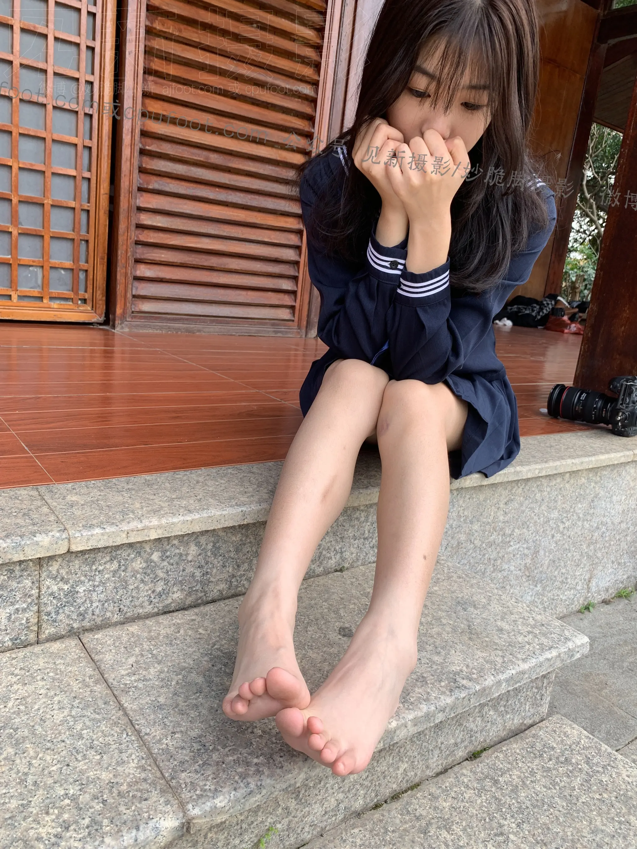 有一个年轻的女孩坐在一栋房子的台阶上