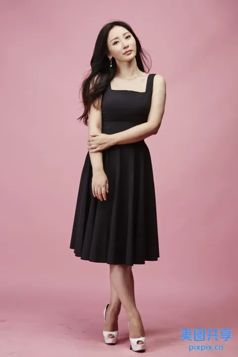 身穿黑色连衣裙的女子摆姿势拍照