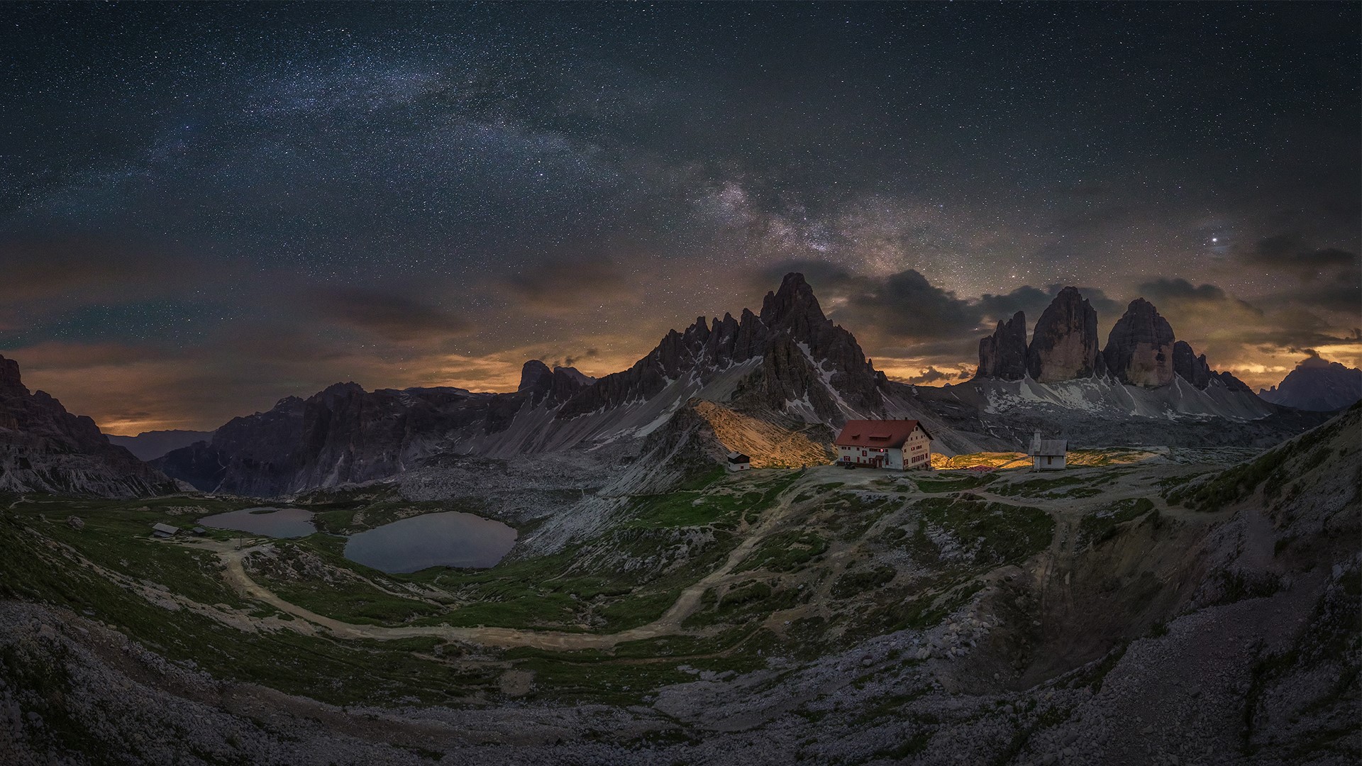 山脉上的星空，前景是一座小房子