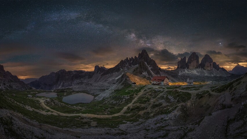 山脉上的星空，前景是一座小房子