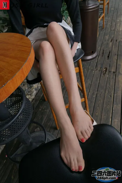有个女人坐在椅子上，脚放在桌子上