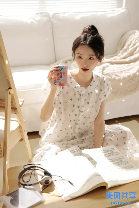 地板上坐着一个女人，手里拿着一本书